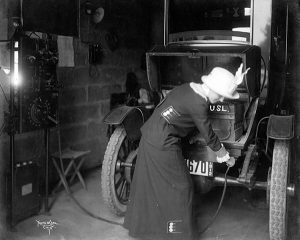 Một người phụ nữ tên Charlotte Shipley sạc pin ô tô điện của mình trong nhà để xe bằng một sợi dây từ máy phát điện quay tay, Cincinnati, Ohio, 1912.